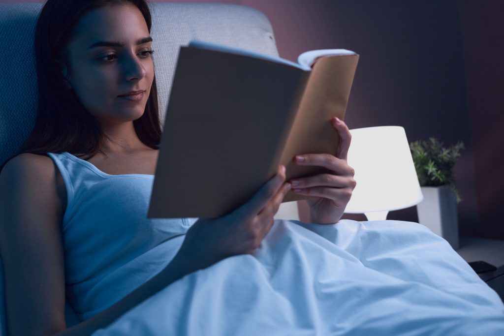 Mujer leyendo libro en la cama